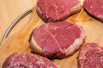 raw steaks on a cutting board. fresh meat. Wooden background