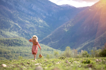 A girl admiring the dawn or sunset of the sun in a picturesque place in the mountains.