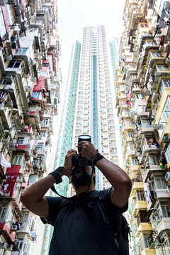 Photographer taking pictures of residencial buildings facades in Hong Kong