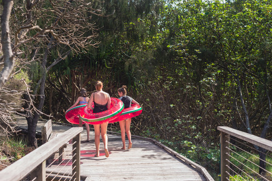 3 teens on a boardwalk with blow up rings