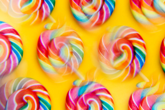 Close-up of rainbow lollipop candies on yellow
