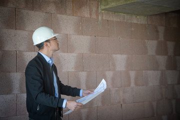 Architect inspects construction outside talking on the phone.