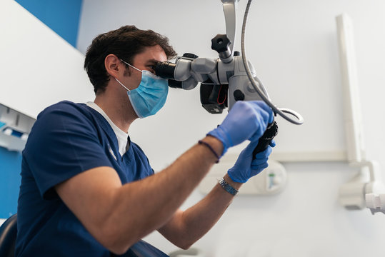 Dentist during a dental intervention using microscope.