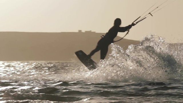 Silhouette of Girl Kitesurfing at Sunset