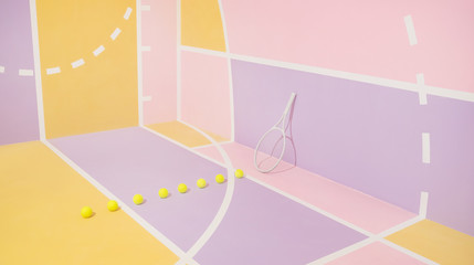 Tennis balls and racket on colorful course.