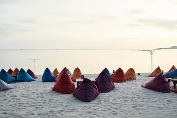 Bean bags ready to watch sunset at seashore.