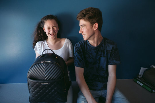 Smiling teenage couple sitting indoors