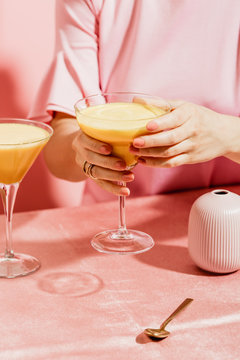 Midsection of woman holding glass of curcuma latte