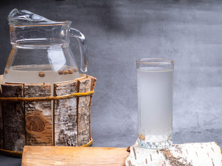Birch natural juice detox in a glass, jug on concrete background.