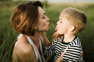 Mother kiss her little son outdoor