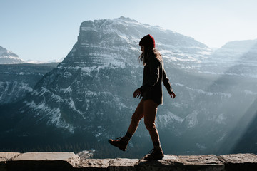 Woman walking along ledge