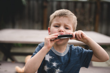 Portrait of boy playing harmonica