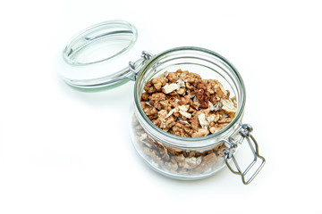 The walnuts stored inside the closable glass bottle isolated on a white background. 