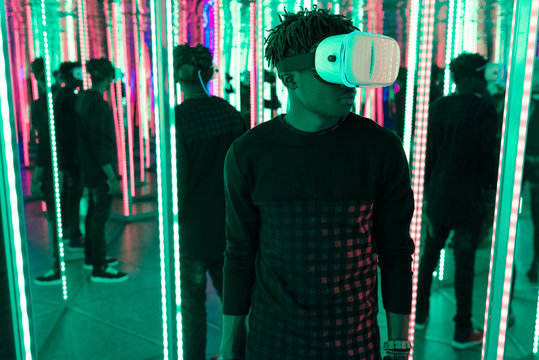Black man using VR glasses in labyrinth