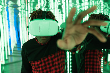 Ethnic youngster using VR glasses in maze