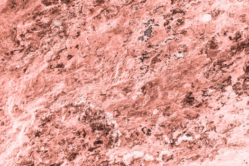 Vintage pink background. Rough painted wall of living coral color. Imperfect plane of beige colored. Uneven old decorative toned backdrop of beige tint. Texture of pink hue. Ornamental stony surface.
