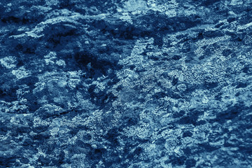 Vintage blue background. Rough painted wall of sapphire color. Imperfect plane of blue colored. Uneven old decorative toned backdrop of cyan tint. Texture of sapphirine hue. Ornamental stony surface.