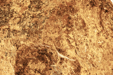 Vintage yellow background. Rough painted wall of aspen gold color. Imperfect plane of golden colored. Uneven old decorative toned backdrop of yellow tint. Texture of gold hue. Ornamental stony surface