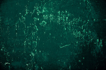 Vintage green background. Rough painted wall of emerald color. Imperfect plane of virid colored. Uneven old decorative toned backdrop of green tint. Texture of emerald hue. Ornamental stony surface.