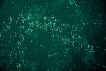 Vintage green background. Rough painted wall of emerald color. Imperfect plane of virid colored. Uneven old decorative toned backdrop of green tint. Texture of emerald hue. Ornamental stony surface.