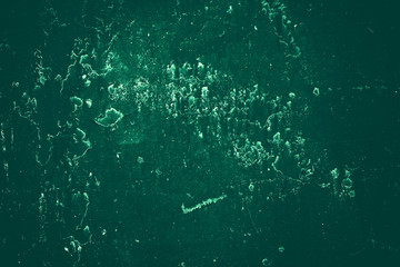 Vintage green background. Rough painted wall of emerald color. Imperfect plane of virid colored. Uneven old decorative toned backdrop of green tint. Texture of emerald hue. Ornamental stony surface.