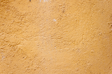 Background rough rustic shabby texture of old wall with yellow cracked plaster
