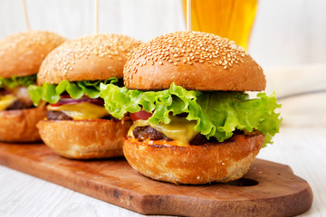 Homemade cheeseburgers and glass of cold beer, side view. Close-up. Selective focus.