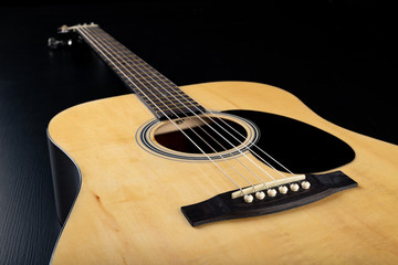 Fototapeta premium Classical guitar on a dark wooden table. Musical instrument stringed.
