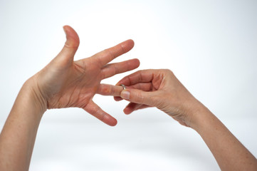 woman's hand taking off the marriage ring after the divorce decree