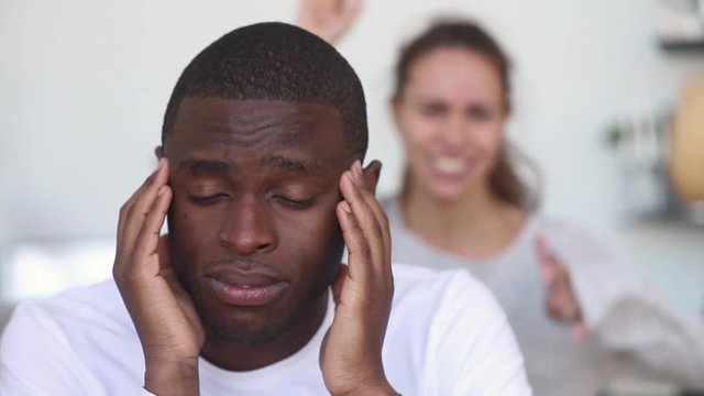 Upset african man tired of argument ignore angry caucasian wife