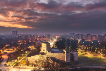 Fototapeta na wymiar Sleepy Pirot blue hour cityscape and burning sunrise sky with iconic, ancient, foreground fortress 
