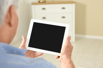 Man using video chat on tablet at home, closeup. Space for text