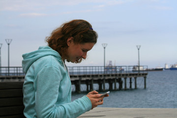 Girl using smartphone at the seaside