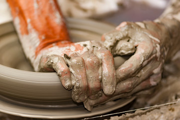 skilled hands, dirty with earth, model, mold and paint the clay, creating works of art