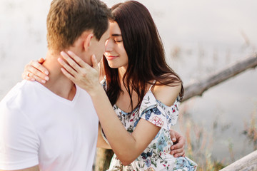 Young loving couple hugging near lake.