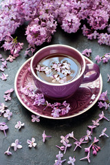 Tea cup and lilac on  dark table