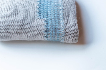 Wool sweater, blue and beige background, blurred texture