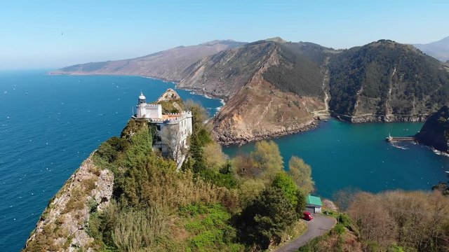 epic fly into Pasaia river with a lighthouse a top a cliff