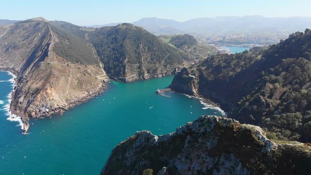 epic fly into Pasaia river with a lighthouse a top a cliff