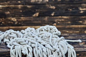 Fototapeta premium Ship rope on rustic wooden background. Copy space.
