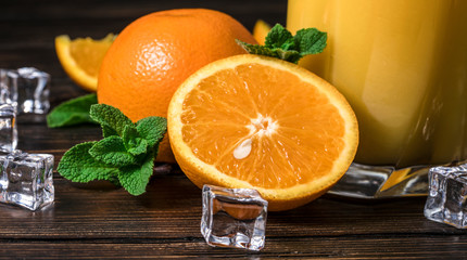 oranges and pieces of ice on a wooden background