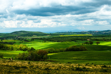 Obraz premium Tuscany spring, rolling hills and windmill on sunset. Rural landscape. Green fields. Italy, Europe