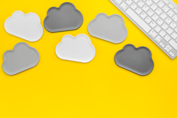 cloud computing concept with clouds and keyboard on yellow background top view space for text