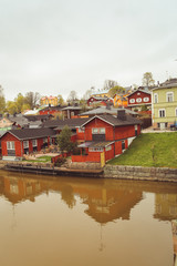 Fototapeta na wymiar Porvoo, Finland - may 2019: cobbled streets of medieval village. river and it's scenic row of old rust-red warehouses