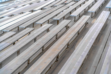 Obraz premium Close up of tiered rows of benches at a sports field viewed on a sunny day.