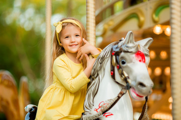 Adorable little girl near the carousel outdoors in Paris, baby girl on the carousel, Happy healthy...