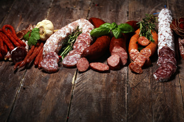 cold meat assortment with delicious salami and  fresh herbs . Variety of meat products including coppa and sausages