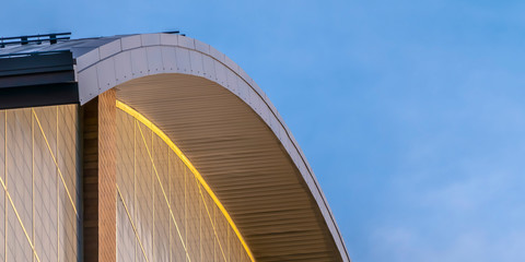 Close up view of the exterior of a building with a curve shaped roof
