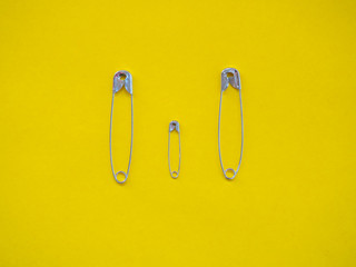 Several safety pins of various sizes in human representation. Concept of traditional family with children