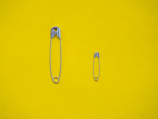 Several safety pins of different sizes. Concept of diversity and inclusion